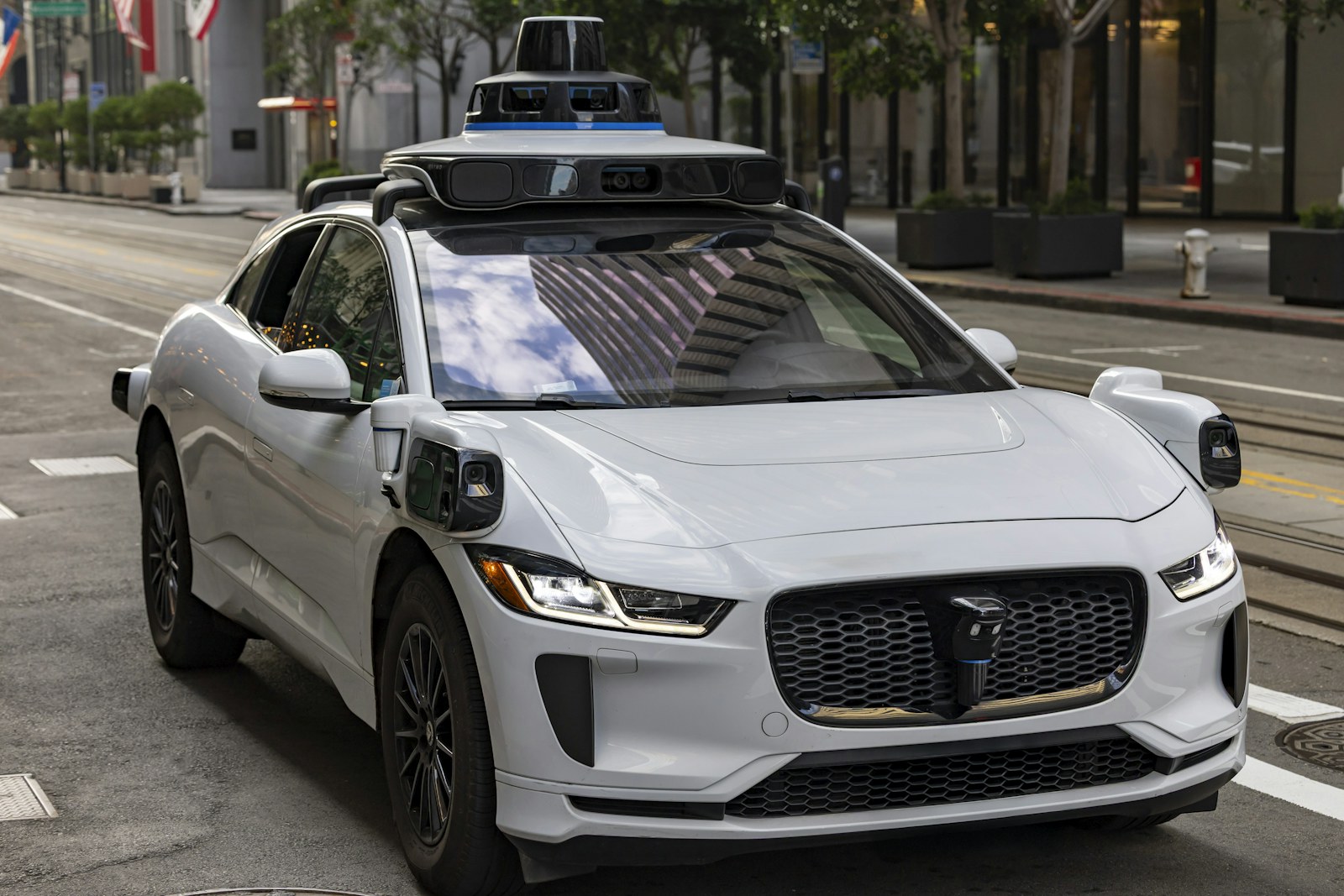 A white self-driving car on a city street