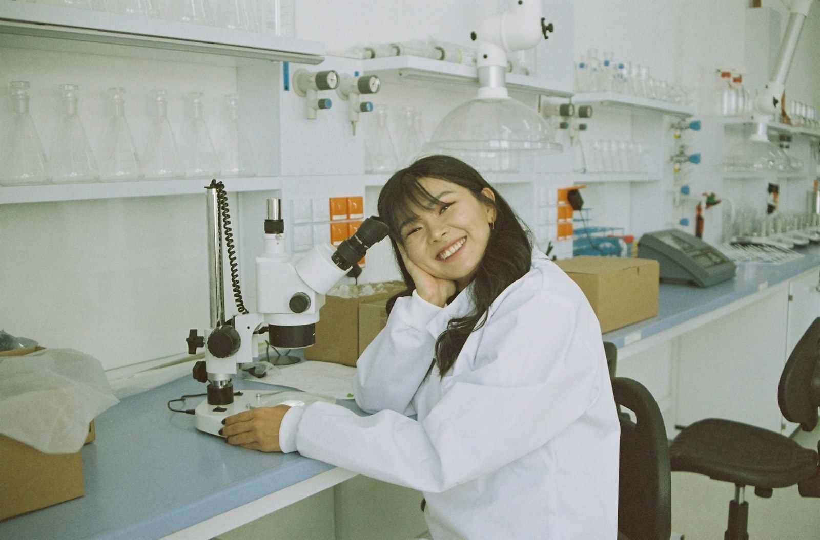 woman in white laboratory gown holding black microphone