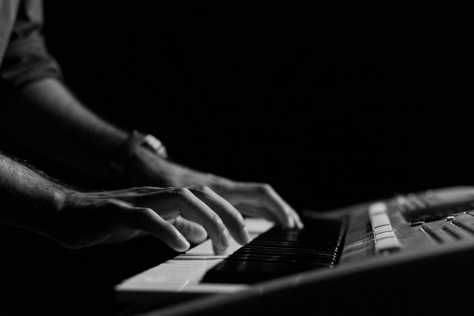 a black and white photo of a person playing a keyboard