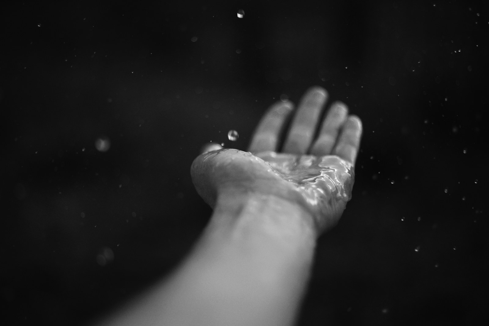 Water droplets splash into an outstretched hand