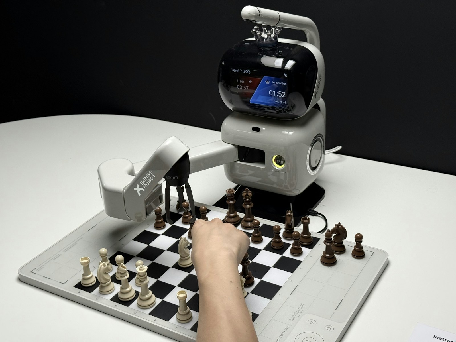 Robot arm playing chess with a human hand