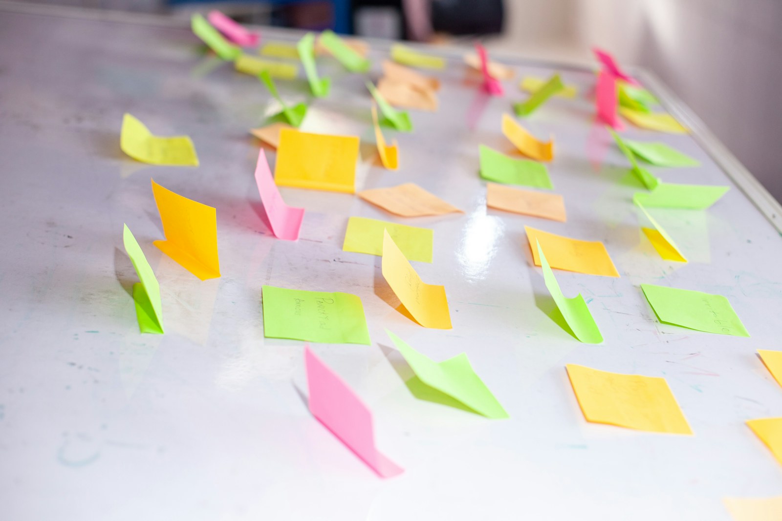 Colorful sticky notes scattered on a white board