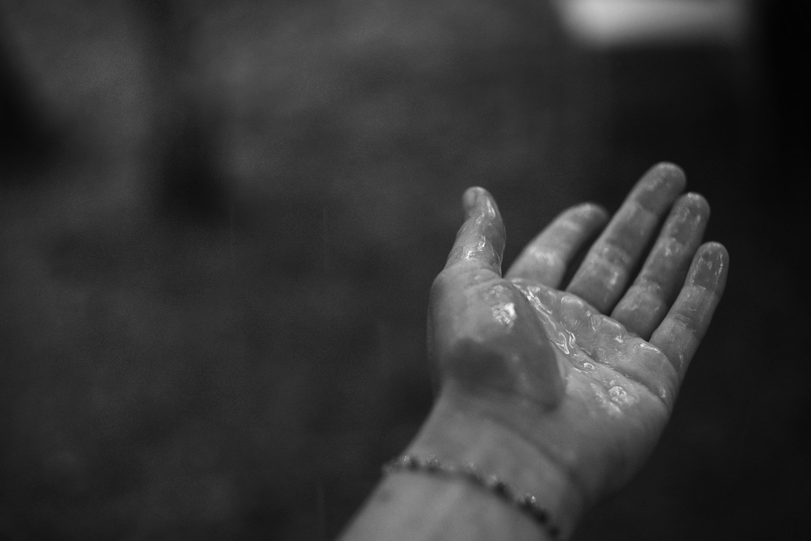A wet hand with a beaded bracelet
