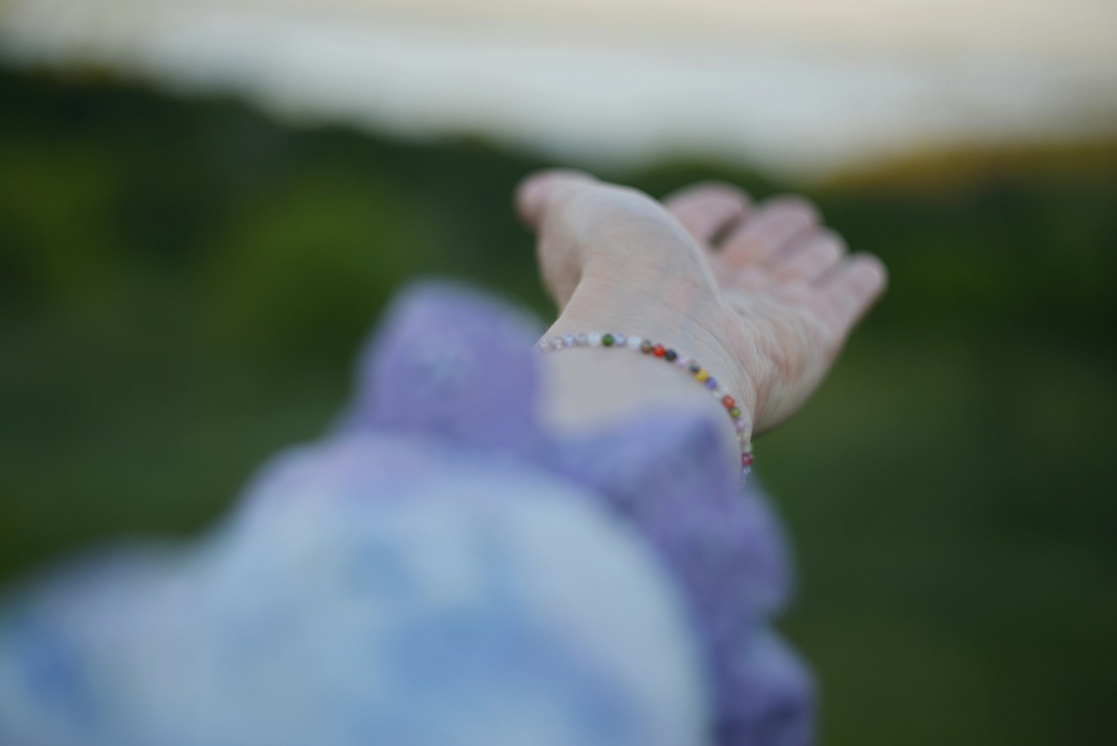 Outstretched hand with a beaded bracelet