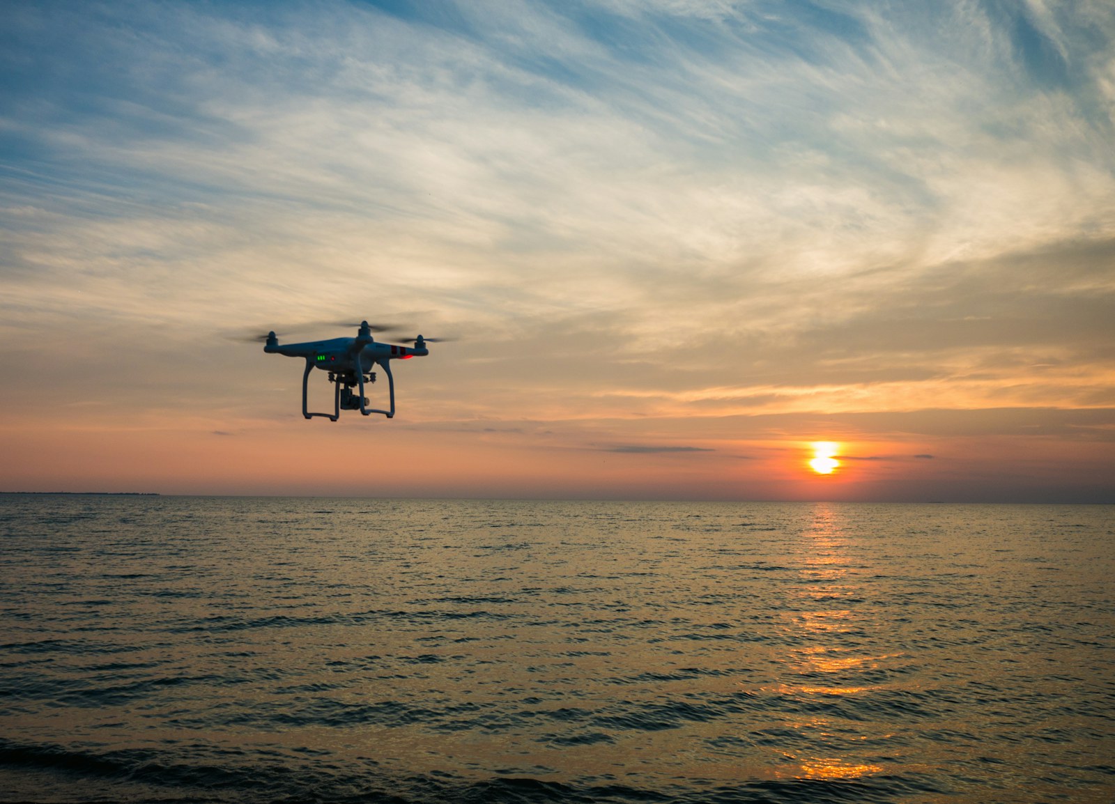 quadcopter flying over body of water