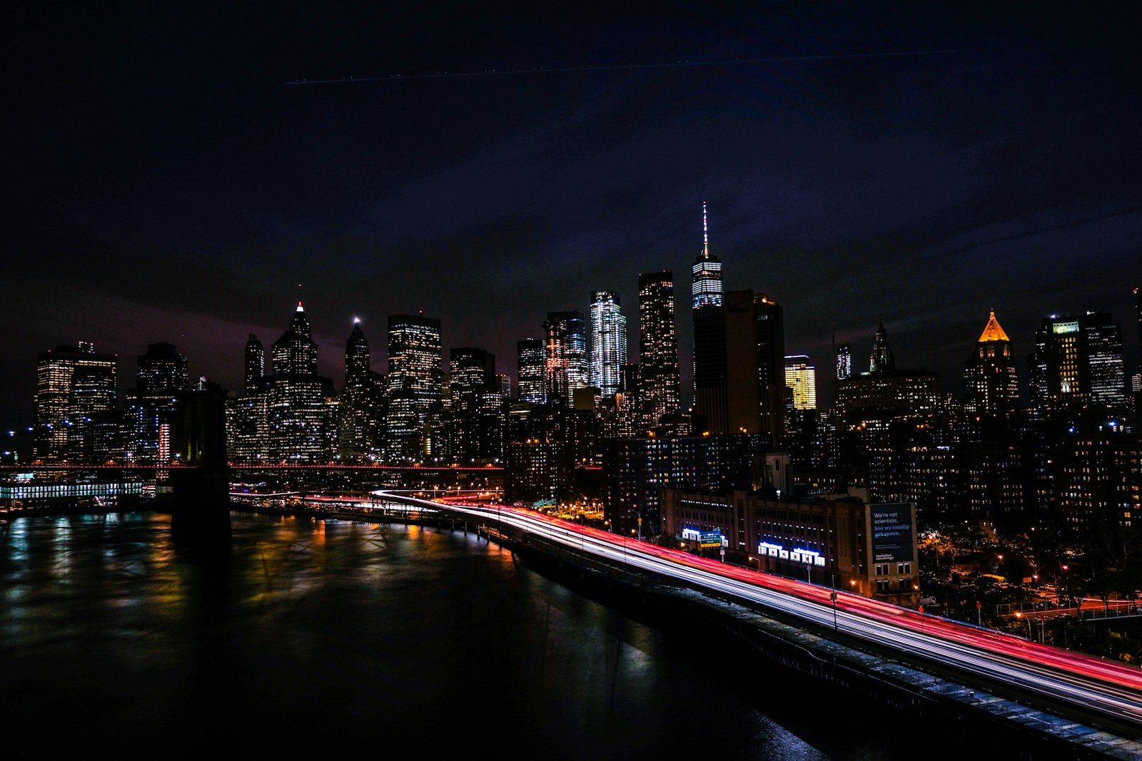 Long exposure light trails on a highway before the illuminated New York City skyline